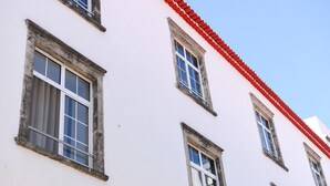 A building with multiple windows and a red roof. - Guestready - Casa das Arcadas (Ponta Delgada)