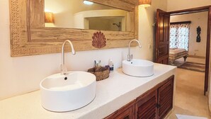 Ein Badezimmer mit zwei Waschbecken, einem großen Spiegel und Holzschränken.