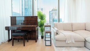 Una sala de estar moderna con un piano, un sofá y vistas de edificios altos.