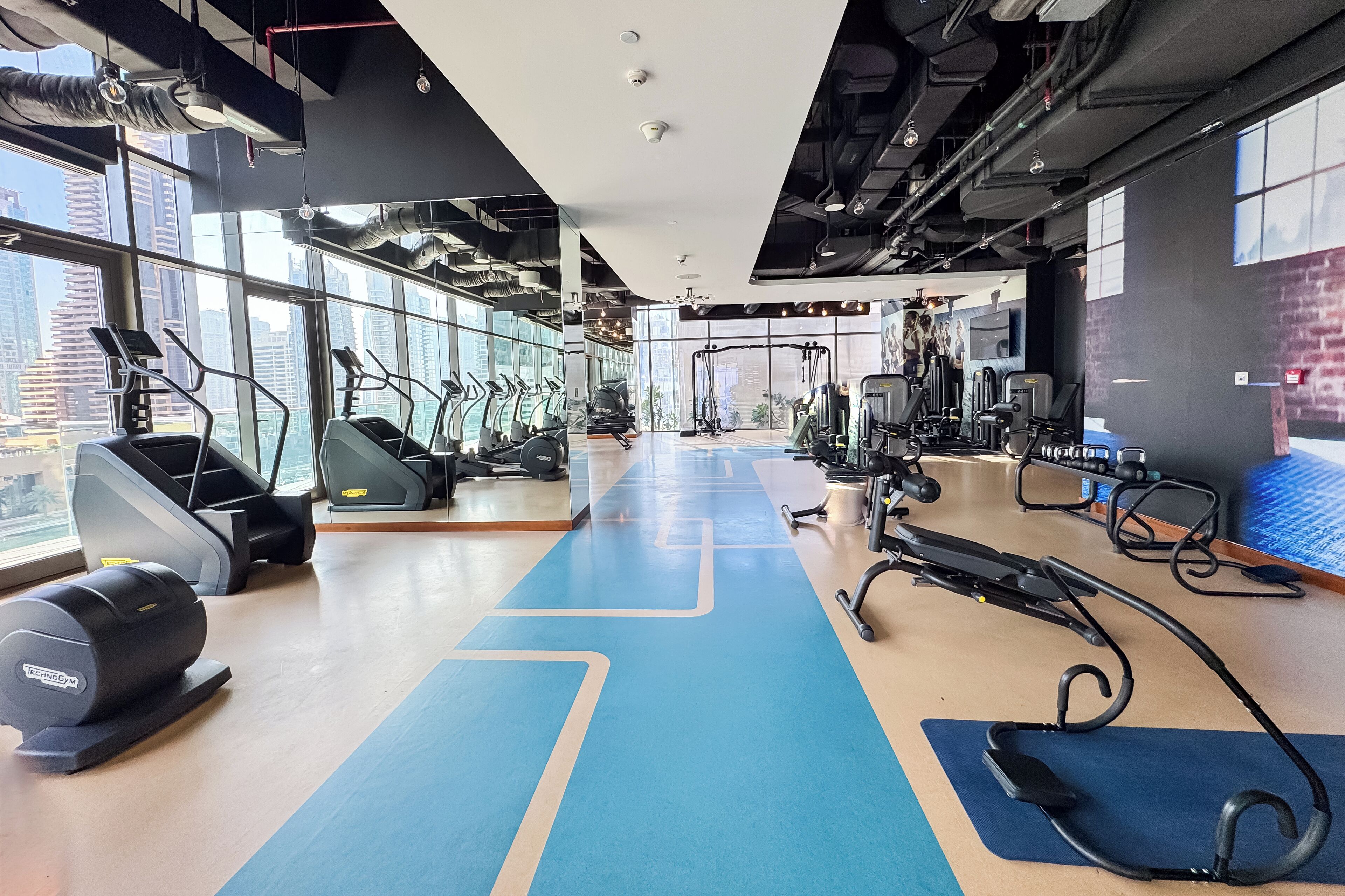 Une salle de sport équipée de tapis de course, de vélos elliptiques et de matériel de musculation.