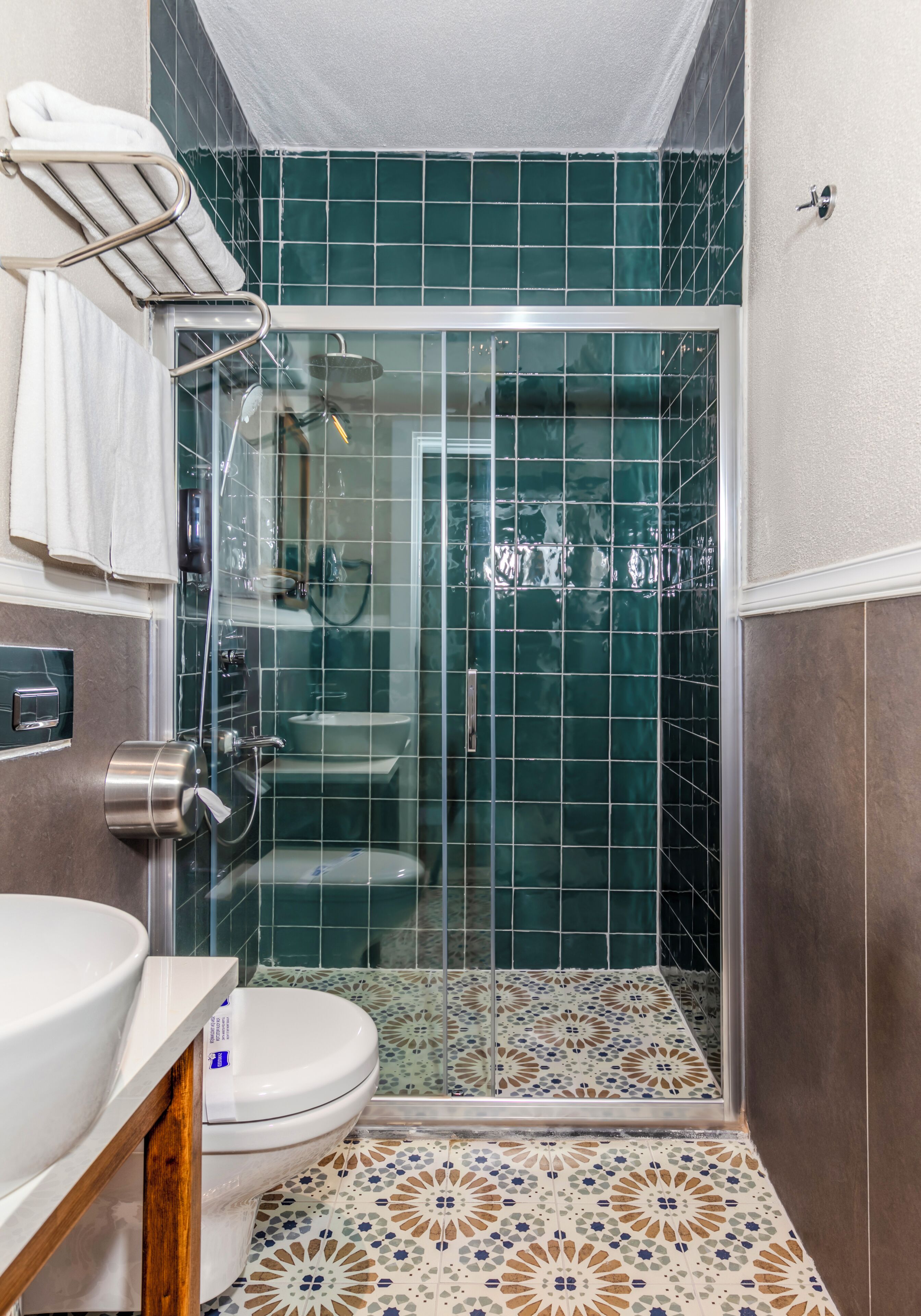 Un baño con ducha de vidrio, inodoro y lavamanos.
