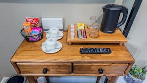 A wooden desk with a coffee maker, a keyboard, and various food items. - Nenesa Hotel İstanbul Airport  (Arnavutkoy)