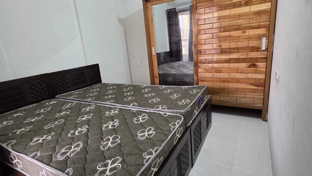 A bedroom with a bed, a wardrobe, and a mirror. - Wellnessghar (Panvel)