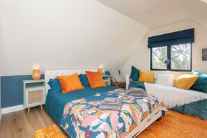 A bedroom with a large bed, two bedside tables, a window with a view, and a ceiling light. - Peaceful Stylish Entire Apartment - Views, Gardens, Firepit, Balcony (Holt)