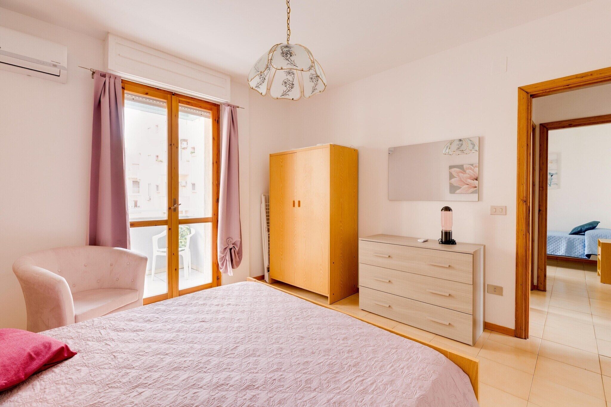 Une chambre à coucher avec un lit, une armoire, une chaise et un bureau.