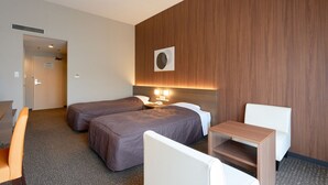A hotel room with two beds, a desk, a chair, a small table, and a wall-mounted air conditioning unit. - Arima Onsen Maple Arima (Kobe)