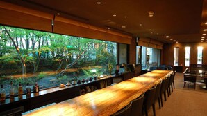 A long wooden bar with a view of a forested area through large windows. - Arima Onsen Maple Arima (Kobe)