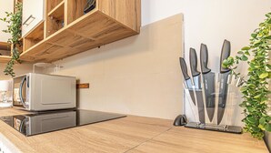 Una cocina con microondas, tostadora y bloque de cuchillos sobre una encimera de madera.