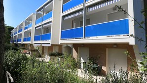 Un immeuble moderne à plusieurs étages, doté de balcons, d’une façade en briques et surplombant un ciel dégagé.