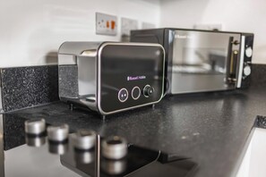 A modern kitchen with a digital interface, a toaster, and a microwave. - Guestready - Gladstone (Liverpool)