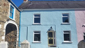 A two-story building with a stone facade and a blue-painted upper section.