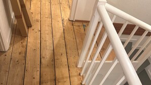 A wooden deck with a white railing leading to a staircase.