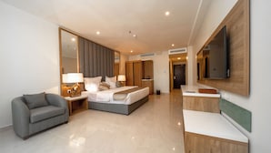 A modern hotel room with a large bed, a sofa, a desk, and a TV mounted on the wall. - Continent Hotel Al Uqayr (Al Uqayr)