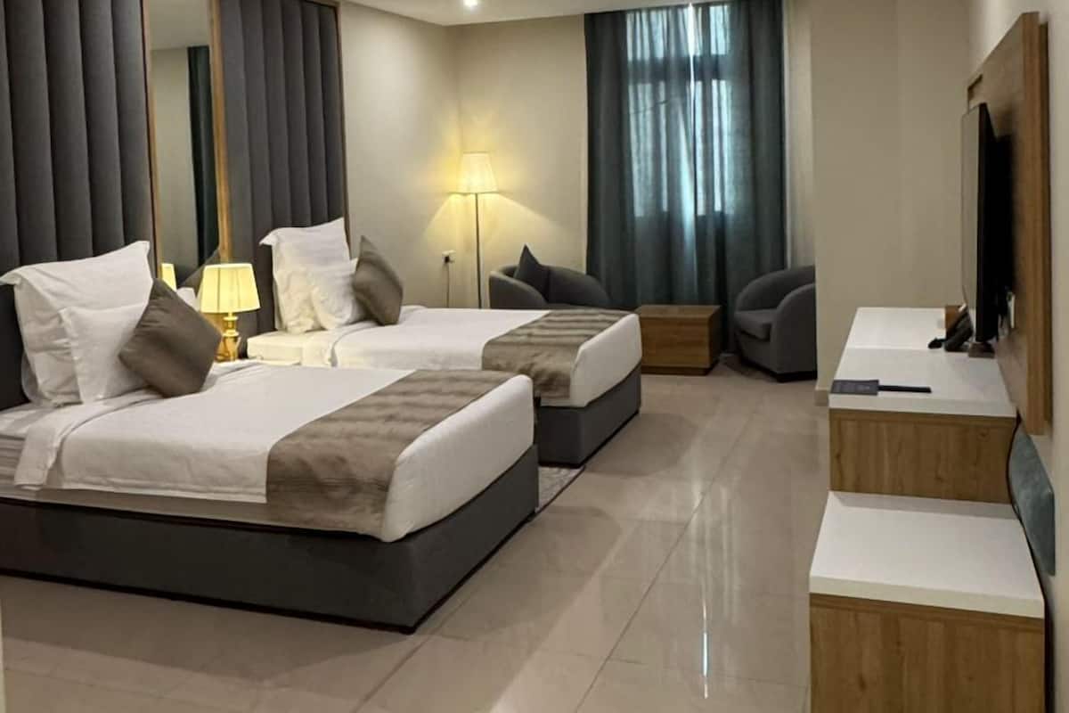 Una habitación de hotel moderna con una cama grande, un escritorio y un televisor.
