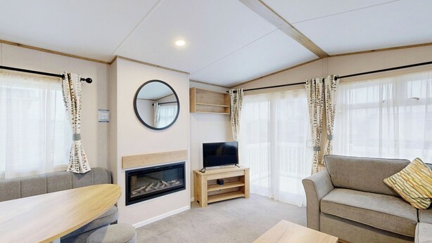 A cozy living room with a fireplace, a television, and a sofa. - Silver 2 Bedroom Holiday Home Pet (Hornsea)