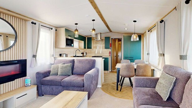 Un intérieur de camping-car moderne comprenant un espace de vie, un coin cuisine et un espace repas.