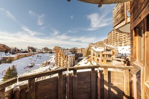 A snowy mountain resort with wooden buildings, a ski slope, and a view of the surrounding landscape. - La Capsule - Immodreams - Avoriaz (Avoriaz)