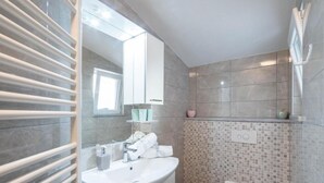 A modern bathroom with a large mirror, a white sink, a toilet, and a shower area. - Casa Della Cava - Private Villa in Seget Donji (Seget)