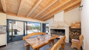 A wooden dining table with benches, a fireplace, and a view of the outside. - Casa Della Cava - Private Villa in Seget Donji (Seget)