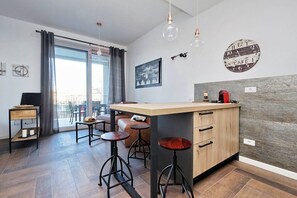 Eine moderne Küche mit einer zentralen Kochinsel, Barhocker und einem Essbereich mit einer Couch und Stühlen.