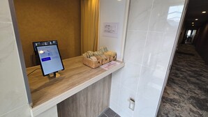 Un comptoir d’accueil équipé d’un écran d’ordinateur, d’une caisse enregistreuse et d’un panier contenant des billets et des pièces de monnaie.