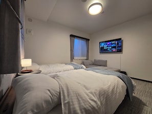 Quarto triplo luxo, várias camas, banheiro privativo, vista para a cidade | Escrivaninha, Wi-Fi de cortesia