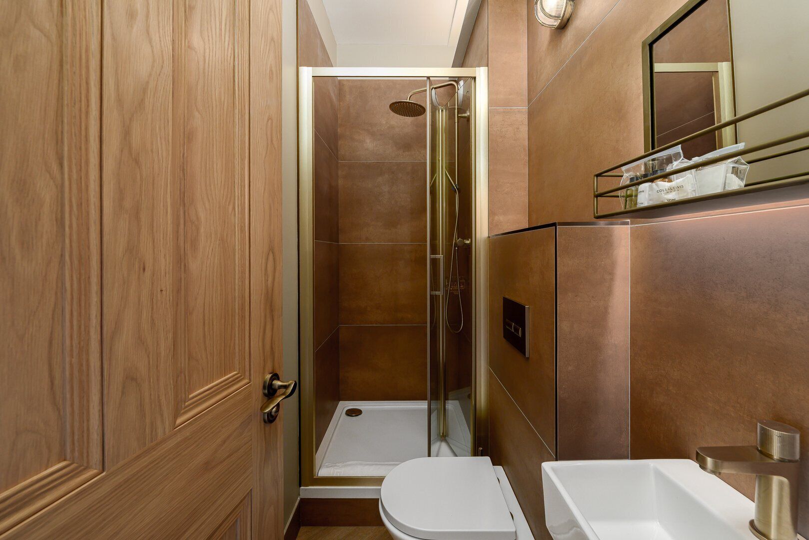 A modern bathroom with a glass shower enclosure, a toilet, and a sink.