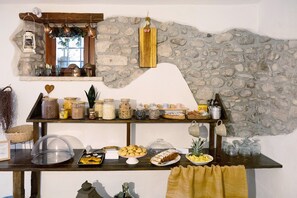 A buffet setup with various food items, jars of condiments, and a stone wall backdrop. - Room 3 – Spacious Double Room with Shared Pool, Wi-Fi, and Air Conditioning (Cavaion Veronese)