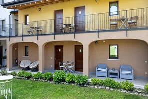 A building with a balcony, outdoor seating, and a garden. - Double Room '4' with Shared Pool, Wi-Fi and Air Conditioning (Cavaion Veronese)