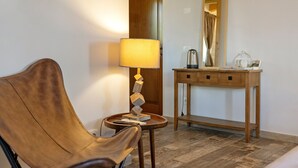 A room with a wooden chair, a small table with a lamp, a wooden console table with a mirror, and a wooden floor. - Room 6 – Spacious Double with Shared Pool, Wi-Fi, and Air Conditioning (Cavaion Veronese)