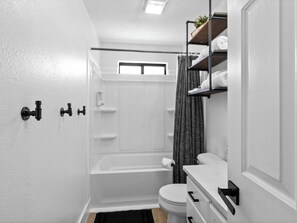 Een haardroger, handdoeken, shampoo, toiletpapier