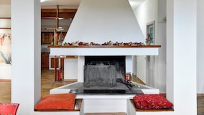 A modern living room with a fireplace, wooden beams, and a red cushion. - Mary Jungle (Sant'Elpidio a Mare)
