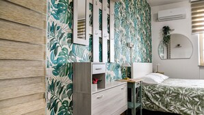 A bedroom with a bed, a dresser, a mirror, and a window with blinds. - Mary Jungle (Sant'Elpidio a Mare)