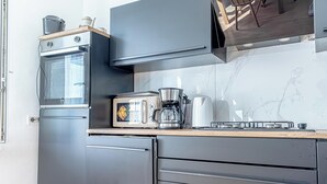 A compact kitchen with a built-in oven, a coffee maker, and a toaster. - Cozy Room Near Landstraße for Long Stay (Vienna)