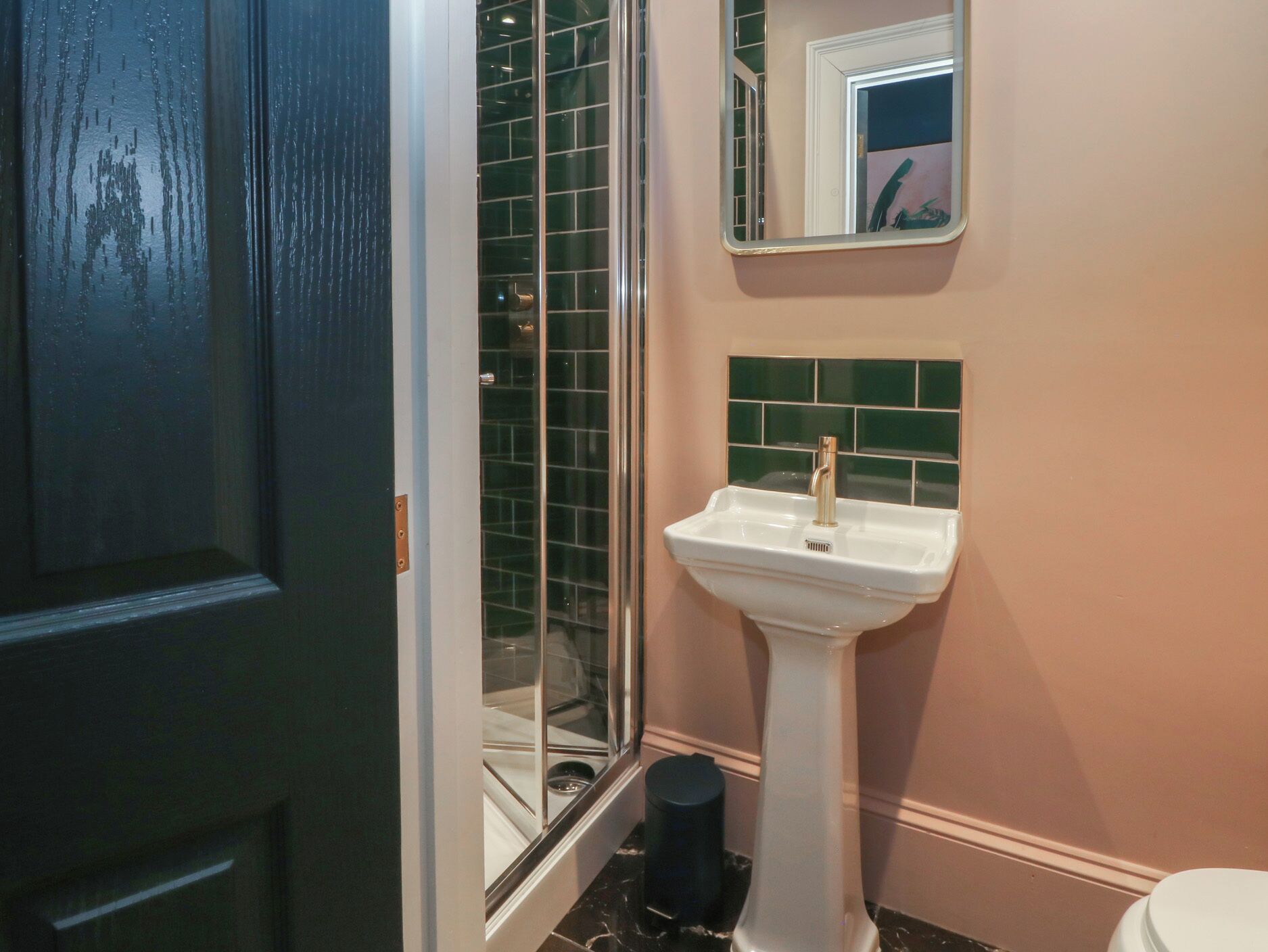 A bathroom with a white sink, a mirror, and a glass shower enclosure.