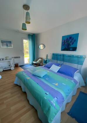A bedroom with a bed, a chair, a desk, a mirror, and a painting on the wall. - Guest Room "Les Hortensias" with Shared Terrace, Private Garden and Wi-Fi (Perros Guirec)
