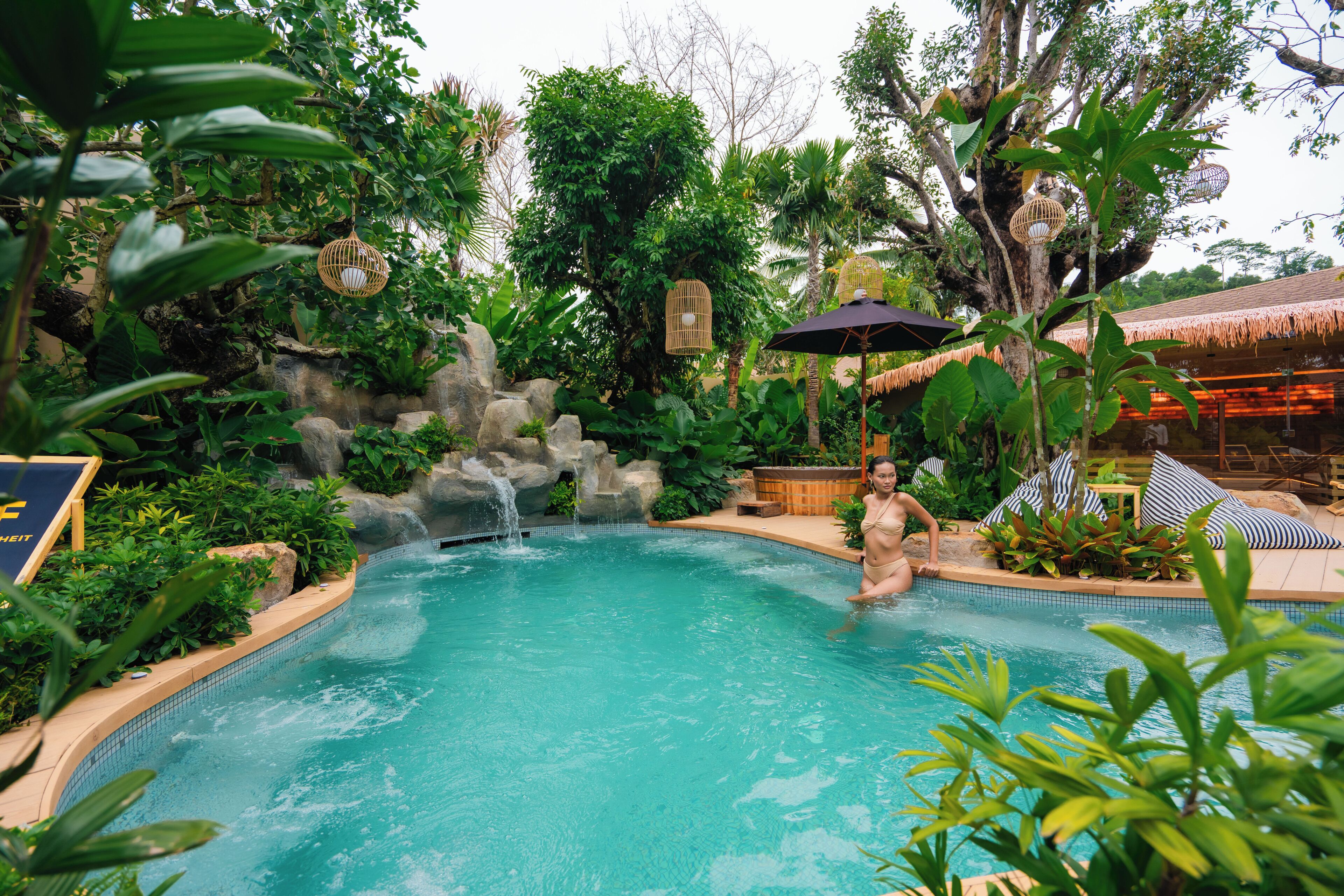 Una piscina al aire libre, sombrillas, tumbonas