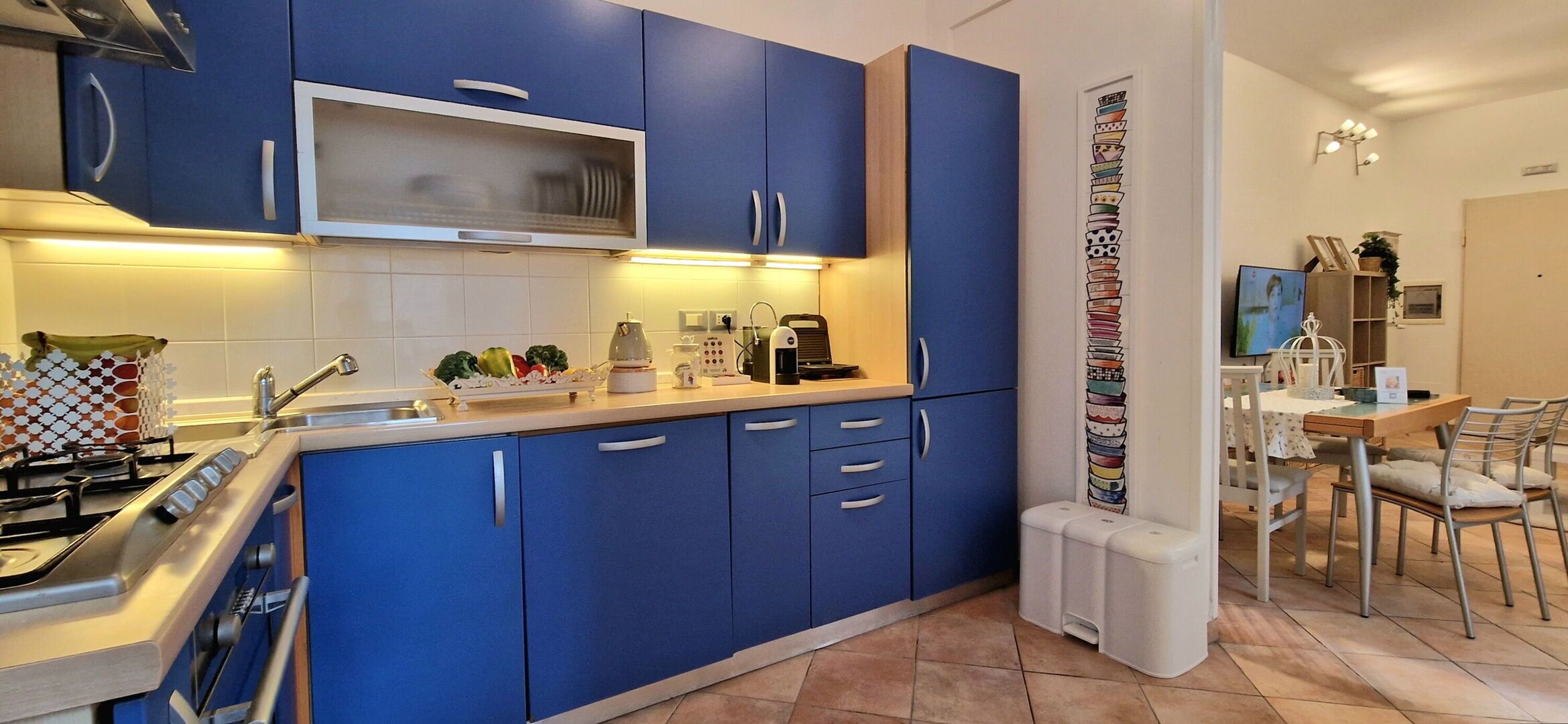 Une cuisine moderne avec des meubles bleus, un four à micro-ondes et une machine à café.
