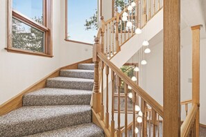 Eine Treppe mit Holzwangen und Teppichstufen, die zu einer oberen Etage führt.