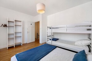 A bunk bed room with a wardrobe and a door.