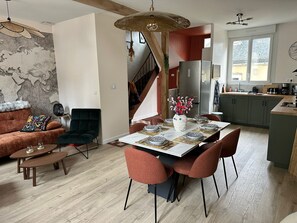 A modern kitchen with a dining area, wooden flooring, and a staircase leading to an upper level. - Bicotea: calm & old-world charm, reinterpreted (Le Mans)