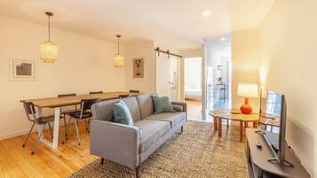 Standaard appartement | Woonruimte | Een 32-inch flatscreentelevisie met kabelzenders