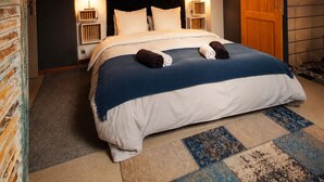 A bedroom with a bed, two bedside lamps, a wooden door, and a sloped ceiling. - Chez Cilia Bed and Breakfast - Garden, Parking | Parc Astérix, Senlis, Chantilly (Fresnoy-le-Luat)
