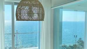 Una habitación con amplios ventanales que dan al mar.