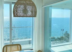 A room with large windows offering a view of the sea.