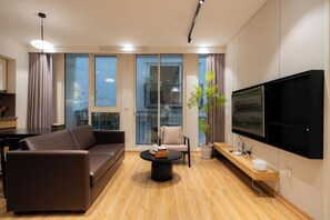 Quarto triplo empresarial, 2 quartos, para não fumantes, vista para o vale | Área de estar | Smart TV 45 polegadas com canais digitais