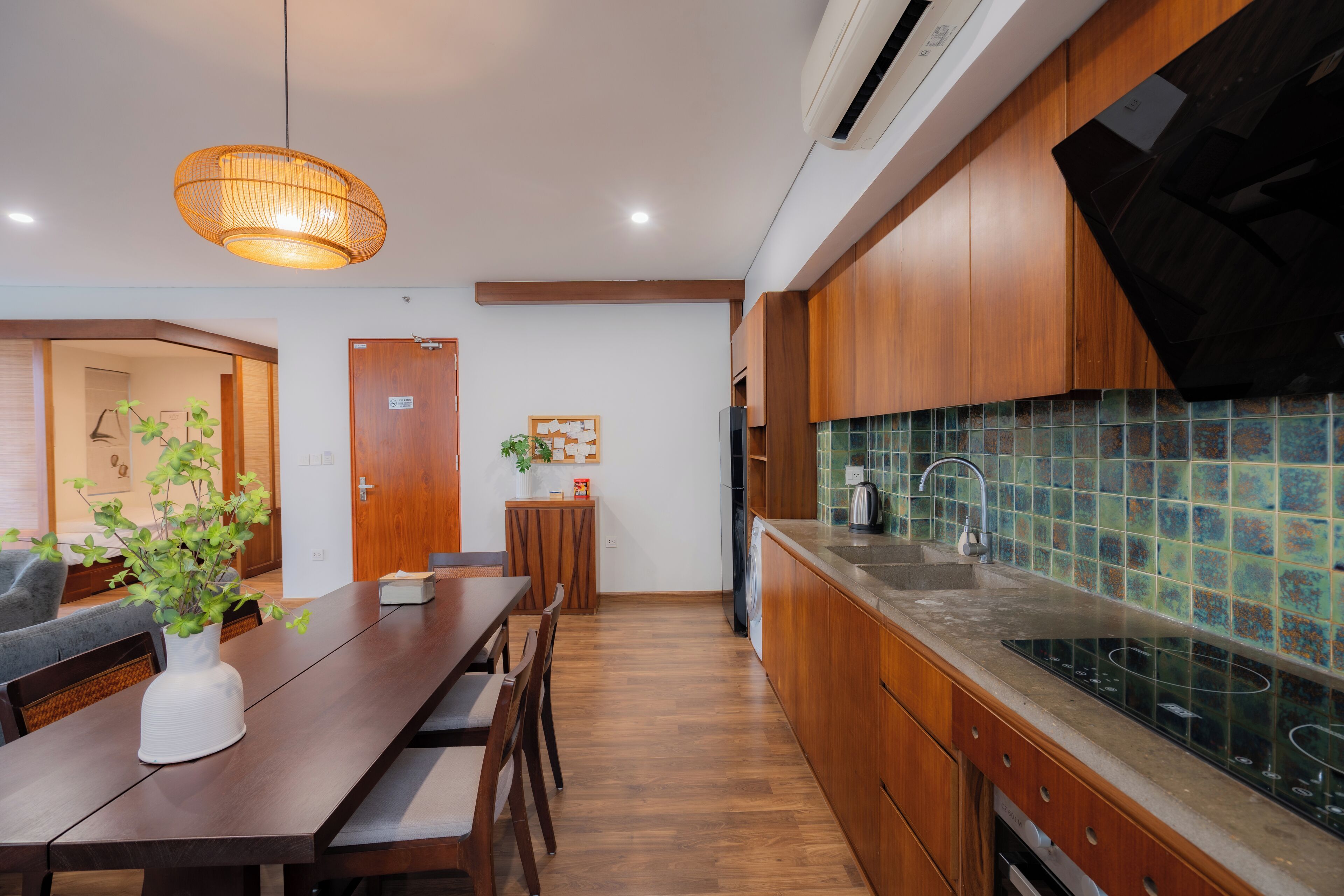 A modern kitchen with wooden cabinets, a tiled backsplash, and a dining area with a wooden table and chairs.