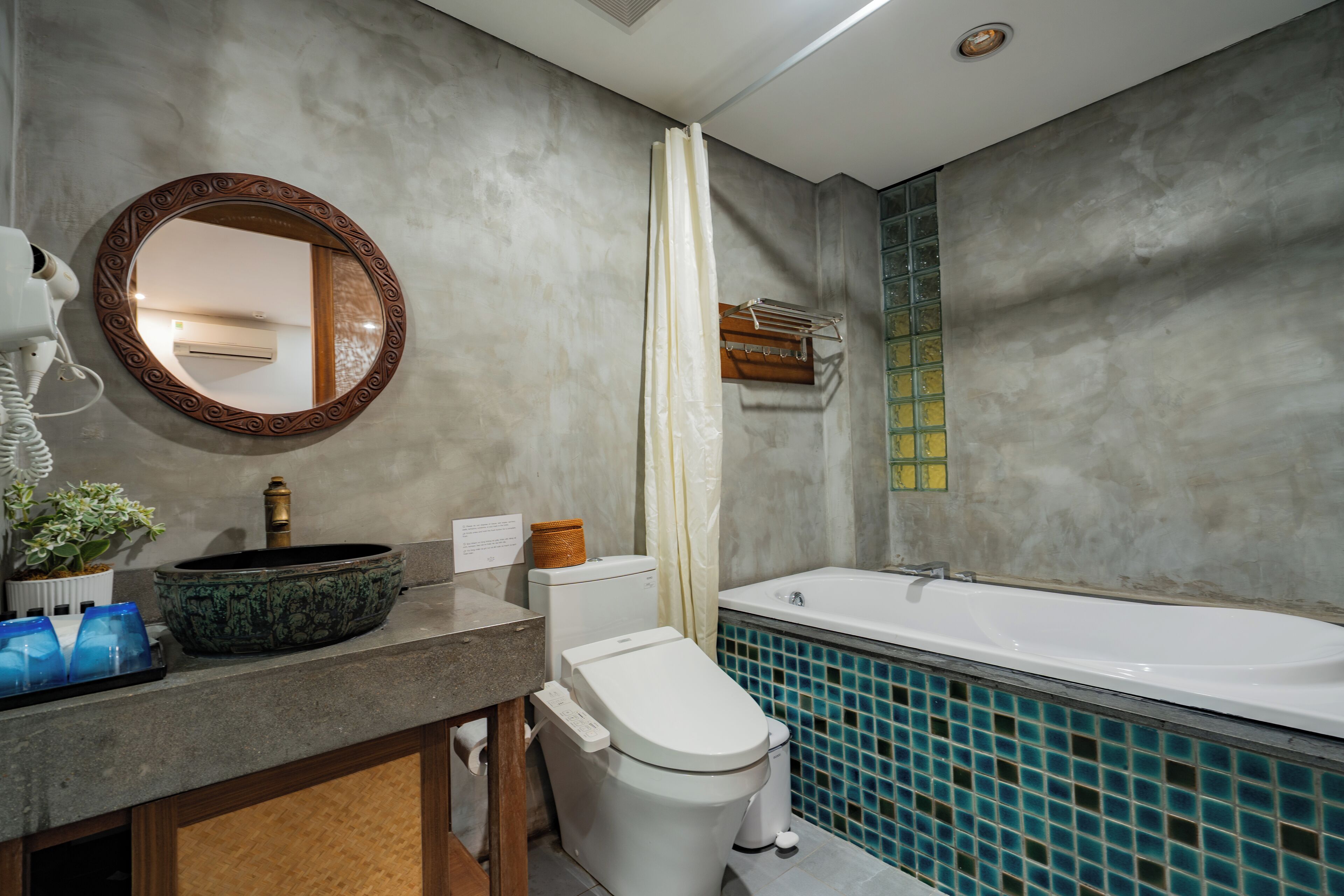Une salle de bain équipée d’une baignoire, de toilettes, d’un lavabo et d’un miroir.