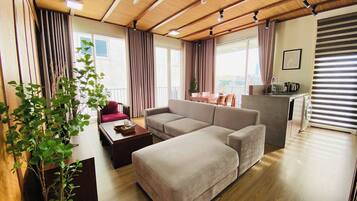Un salon moderne avec un canapé, une table basse et une plante en pot.