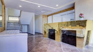 Un salon moderne avec une cheminée, un escalier et une grande fenêtre.